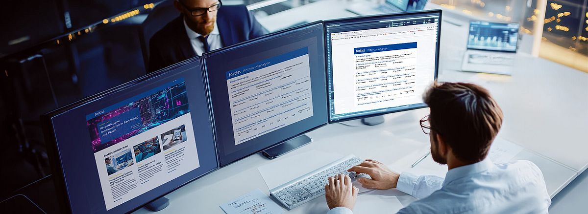 Mann vor Bildschirmen